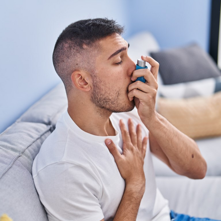 young-hispanic-man-using-inhaler-sitting-sofa-home (Gemiddeld).jpg